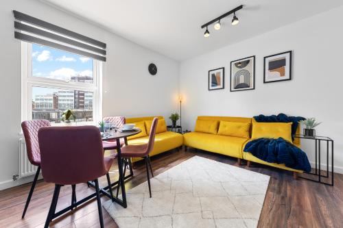 a living room with a yellow couch and a table at 20 Percent Off-Sleeps 11-Central-Games-Free Parking in Southampton