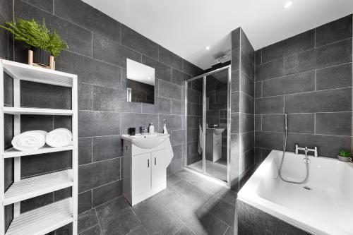 a bathroom with a tub and a sink and a bath tub at 20 Percent Off-Sleeps 11-Central-Games-Free Parking in Southampton