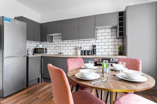 a kitchen with a wooden table and pink chairs at 20 Percent Off-Sleeps 11-Central-Games-Free Parking in Southampton
