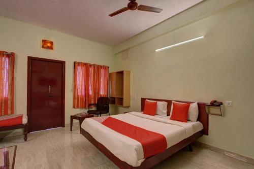 1 dormitorio con 1 cama grande con almohadas rojas en OYO Hotel Radhakrishna, en Madurai