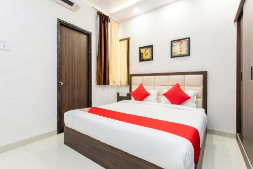 a bedroom with a large bed with red pillows at OYO Happy Home in Bhopal