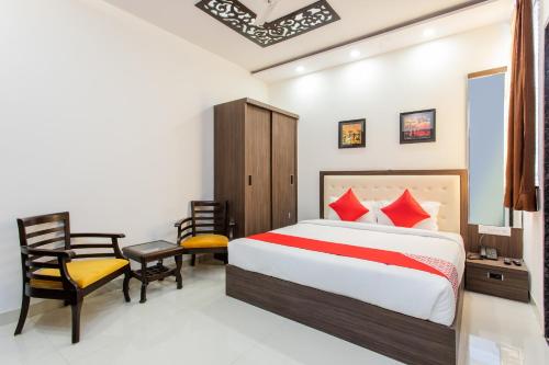 a bedroom with a bed and a desk and a chair at OYO Happy Home in Bhopal