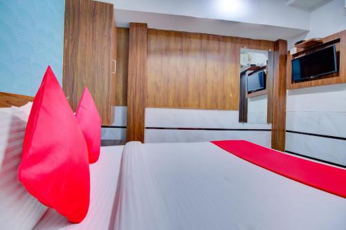 a bedroom with a white bed with red pillows at OYO Hotel Sion Residency in Mumbai