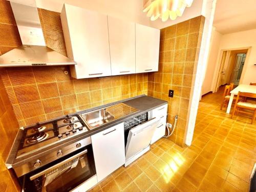 a kitchen with white cabinets and a stove top oven at Frau, grazioso trilocale in centro a Numana con spazio esterno in Numana