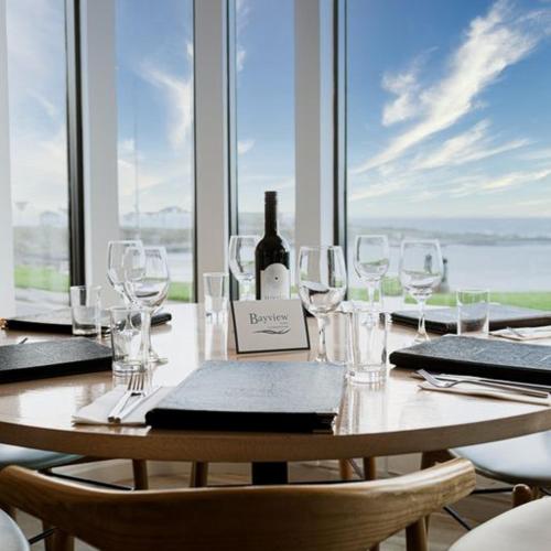 a table with glasses and a bottle of wine on it at Bayview Hotel in Bushmills