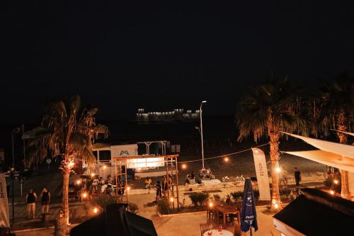 a view of a beach at night with palm trees at Angel Beach Hotel Kızkalesi Mersin in Erdemli