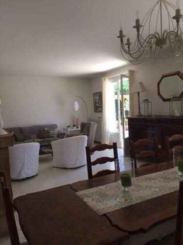 un salon avec une table, des chaises et un canapé dans l'établissement Villa Amahenthe, à Six-Fours-les-Plages
