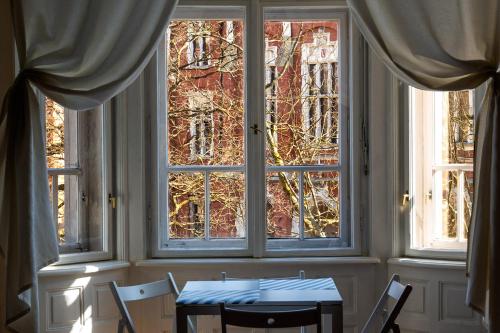 mesa y sillas en una habitación con 2 ventanas en Trzy Kafki Private Rooms, en Cracovia