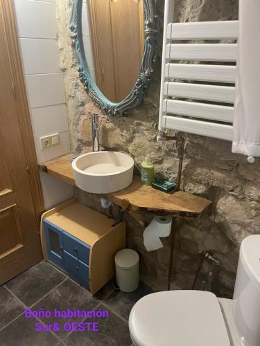 a bathroom with a sink and a mirror at Apartamentos caravia, el cachucho in Duesos