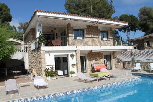 eine Villa mit einem Pool vor einem Haus in der Unterkunft La casa dels Boscos in Tarragona
