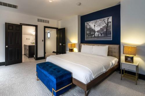 1 dormitorio con 1 cama grande con reposapiés azul en Main Street Oasis - with Parking en Covington