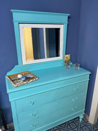 a blue dresser with a mirror on top of it at La casetta della Letizia in Mondello