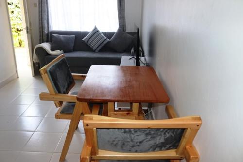 a table and chairs in a living room with a couch at Aisura place in Nairobi