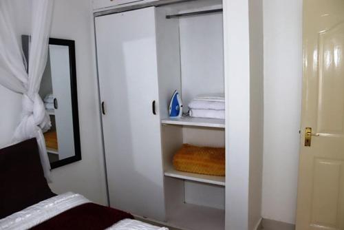 a bedroom with a closet with towels and a mirror at Aisura place in Nairobi