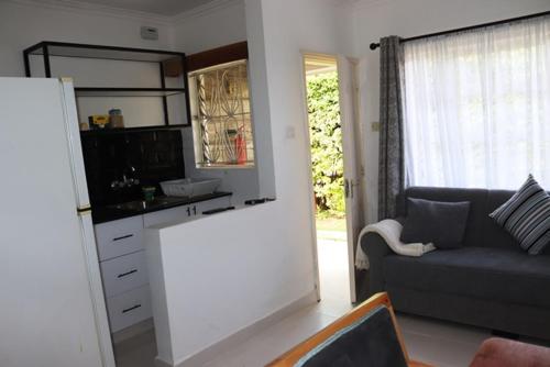 a kitchen and a living room with a couch at Aisura place in Nairobi