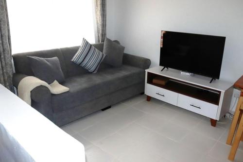 a living room with a couch and a flat screen tv at Aisura place in Nairobi