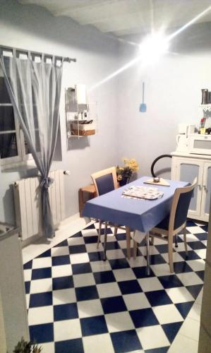 a kitchen with a blue table and chairs on a checkered floor at Studio confortable à Thilouze de 55 m² avec jardin privatif in Thilouze