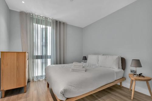 ein weißes Schlafzimmer mit einem Bett und einem Fenster in der Unterkunft Spacious Two Bedroom Apartment at Wembley Park in London