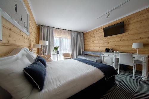 a bedroom with a bed and a desk and a television at New Willa Jan in Zakopane