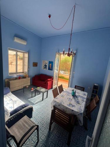 a living room with a table and a red couch at La casetta della Letizia in Mondello