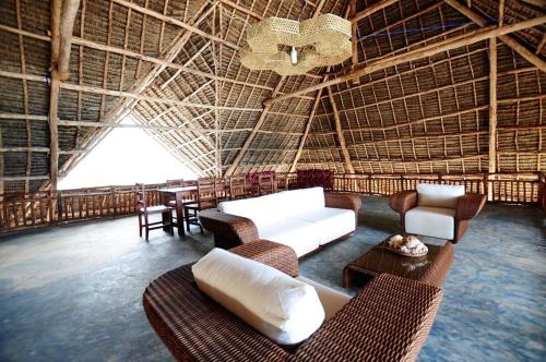 un soggiorno con un divano bianco e sedie di Villa NOAH BEACH ZANZIBAR a Kiwengwa