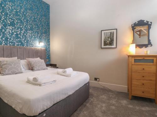 a bedroom with a bed with two towels on it at Windermere Central in Windermere