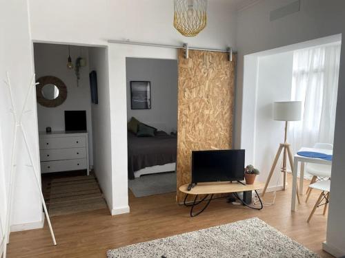 a bedroom with a bed and a table with a laptop at Alba Beach Boutique Apartment in Estoril