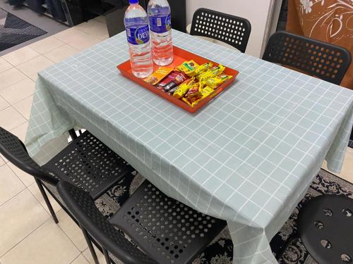 a table with two bottles of water and a tray of food at Rumah 2029 in Masjid Tanah