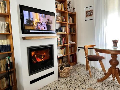 a living room with a fireplace and a television on a wall at Casa Morería in Guadalcanal