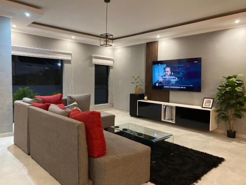 uma sala de estar com um sofá e uma televisão de ecrã plano em North Pole em Darkton