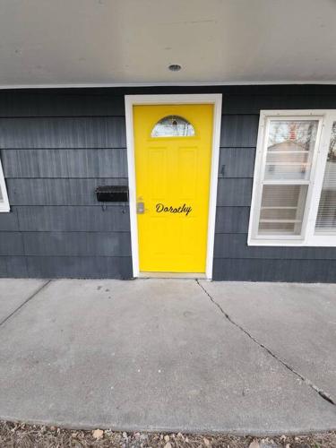 una porta gialla sul lato di una casa di Dorothy - The Hamilton Suites a Hamilton
