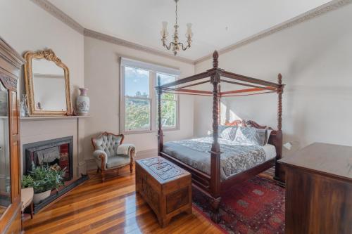 a bedroom with a canopy bed and a fireplace at Derby Bank House- Heritage listed two bedroom old school B&B suite or a self contained cabin in Derby