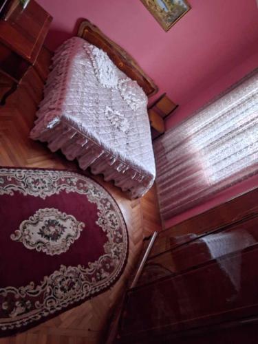 a bedroom with a bed and a rug and a window at NINO in Kobuleti