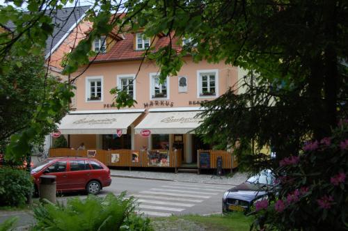 a building with a car parked in a parking lot at Penzion Markus - Pivovar - Brewery Frymburk in Frymburk
