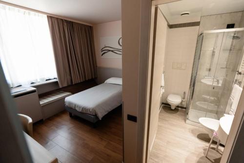 um quarto de hotel com uma cama e um chuveiro em Hotel Ristorante I Castelli em Alba
