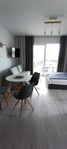 Un dormitorio con una cama y una mesa y sillas. en Flamingo 31, en Międzyzdroje
