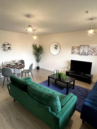 a living room with a green couch and a table at Spacious One Bedroom Apartment in Hemel Hempstead