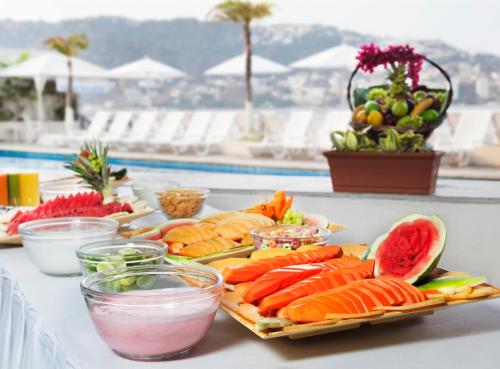 a buffet of food on a table next to a pool at Calinda Beach Acapulco in Acapulco