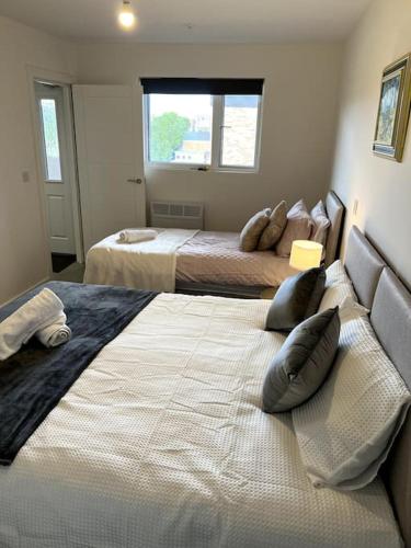 a bedroom with two beds and a window at Spacious One Bedroom Apartment in Hemel Hempstead