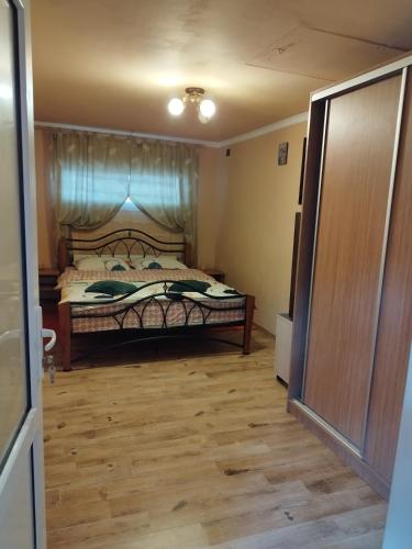 sypialnia z łóżkiem i drewnianą podłogą w obiekcie Casa Sofiandra w mieście Paleu
