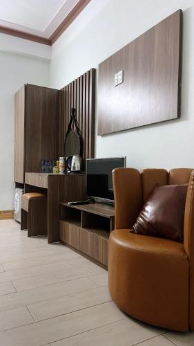 a living room with a couch and a television at Cường Thịnh Hotel in Na Dao Tổng