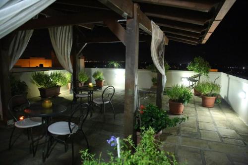 a patio with tables and chairs and potted plants at B&B Borgosolare in Specchia