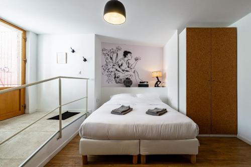 una camera con un letto bianco e una scala di La Maison George a Flavigny-sur-Ozerain
