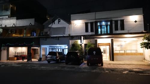 two cars parked in front of a building at night at Hotel Pelangi HS in Ngabean