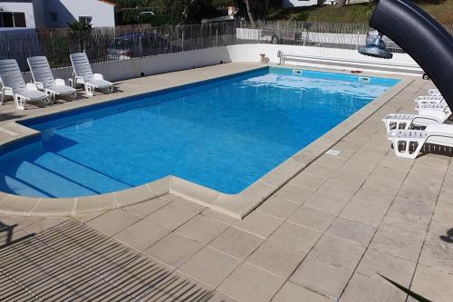 une grande piscine avec des chaises dans l'établissement Maison à 200m de la plage, à La Cotinière
