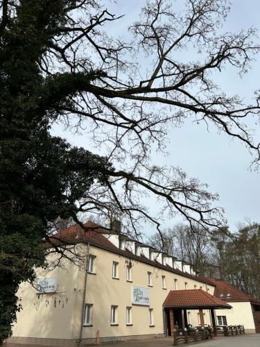 - un grand bâtiment blanc avec un pavillon en face dans l'établissement Leśny Dom, à Barlinek