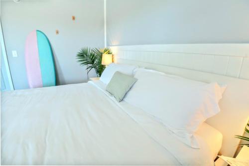 a bed with white sheets and pillows in a room at Tower Circle Motel in Buxton
