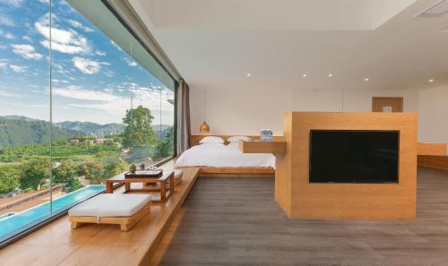 a bedroom with a bed and a large window at Avatar Mountain Resort in Zhangjiajie