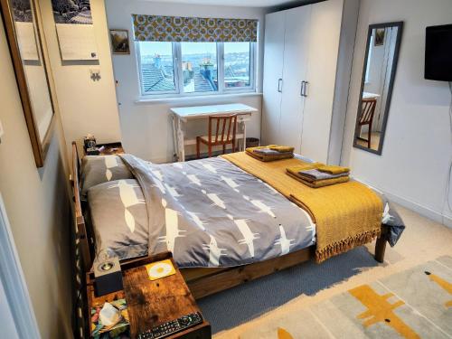 sypialnia z łóżkiem, stołem i oknem w obiekcie Large light loft room - en suite w Brighton and Hove