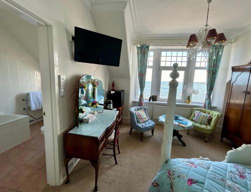 a bedroom with a bed and a desk and a mirror at Tigh Na Mara Guest House Rosemarkie- breakfast optional in Rosemarkie